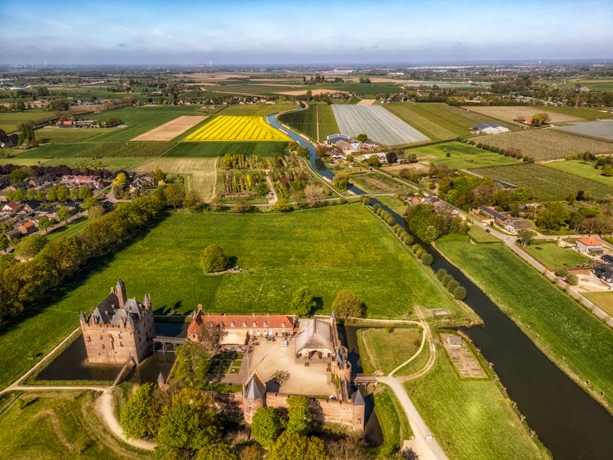 Explore a stunning aerial view of a historic castle amidst the vibrant countryside in the Netherlands.